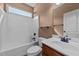 Well-lit bathroom with a combined shower and tub unit, matching toilet, and a wooden vanity at 1141 Contender Dr, Clayton, NC 27520
