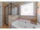 Bathroom with jetted tub, walk-in shower, tile surround and decorative window at 1141 Contender Dr, Clayton, NC 27520