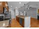 Kitchen island with sink and dishwasher with view to the fireplace in the Gathering room at 1141 Contender Dr, Clayton, NC 27520