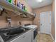 Laundry room with washer, dryer, storage shelf, and access door at 1141 Contender Dr, Clayton, NC 27520