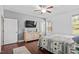 This bedroom has hardwood floors, ceiling fan, a dresser, and a large window at 115 Mill Run Ln, Sanford, NC 27330