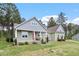 Charming two-story home with landscaped yard, front porch seating area, and craftsman-style architecture at 115 Mill Run Ln, Sanford, NC 27330