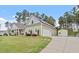 View of home with detached garage, long driveway, well manicured lawn, and a storage shed at 115 Mill Run Ln, Sanford, NC 27330