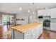 Open concept kitchen featuring a large island with seating, a dining area, and stainless appliances at 115 Mill Run Ln, Sanford, NC 27330