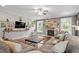 Cozy living room with a stone fireplace, hardwood floors, and large windows at 115 Mill Run Ln, Sanford, NC 27330