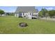 Backyard with patio, fire pit, and lush lawn, perfect for relaxing and outdoor entertaining at 1156 Darius Pearce Rd, Youngsville, NC 27596