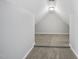 Hallway with neutral carpet leads to a large bonus space with a peaked ceiling at 1156 Darius Pearce Rd, Youngsville, NC 27596