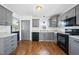 Modern kitchen with gray cabinets, granite countertops, and stainless steel appliances, offering a stylish and functional cooking space at 1156 Darius Pearce Rd, Youngsville, NC 27596