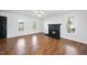 Inviting living room featuring hardwood floors, fireplace, and multiple windows, providing a warm and bright living space at 1156 Darius Pearce Rd, Youngsville, NC 27596