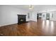 Spacious living room featuring a fireplace, hardwood floors, and ample natural light, perfect for gatherings and relaxation at 1156 Darius Pearce Rd, Youngsville, NC 27596