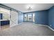 Spacious primary bedroom with a bay window, blue walls, and a modern ceiling fan at 1156 Darius Pearce Rd, Youngsville, NC 27596