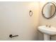 Bathroom features a pedestal sink, round mirror, and white walls at 116 Old Maple Ln, Durham, NC 27713
