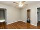 Bedroom featuring hardwood floors, ceiling fan, and access to bathrooms at 116 Old Maple Ln, Durham, NC 27713