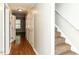 Hallway with hardwood floors leads to carpeted stairs with white trim at 116 Old Maple Ln, Durham, NC 27713