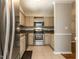 Kitchen with stainless steel appliances, tiled floors, and white cabinets at 116 Old Maple Ln, Durham, NC 27713