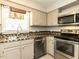 The kitchen features stainless steel appliances, neutral cabinets, and tiled backsplash at 116 Old Maple Ln, Durham, NC 27713