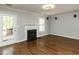 Bright living room featuring hardwood floors, fireplace, and a door to the outside deck at 116 Old Maple Ln, Durham, NC 27713