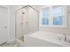 Elegant bathroom featuring a soaking tub and walk-in shower with glass surround at 1245 Porters Call Dr, Wendell, NC 27591