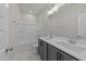 Well-lit bathroom with dual sinks, marble floors, and combination shower and tub at 1245 Porters Call Dr, Wendell, NC 27591