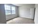 Bright bedroom with carpeting, a large window with neighborhood views, and a white door at 1245 Porters Call Dr, Wendell, NC 27591