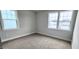 Bright carpeted bedroom with two large windows providing ample natural light and views of the neighborhood at 1245 Porters Call Dr, Wendell, NC 27591