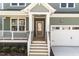 Charming front porch featuring stone columns, wood steps, and a decorative front door at 1245 Porters Call Dr, Wendell, NC 27591