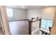 Upstairs hallway with wood floors, a white staircase, and a view into another room with windows at 1245 Porters Call Dr, Wendell, NC 27591