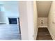 A well-lit hallway with a fireplace visible in the adjacent room, and storage behind a door at 1245 Porters Call Dr, Wendell, NC 27591