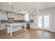 Modern, bright kitchen featuring white cabinets, tiled backsplash, a large island, and stainless steel appliances at 1245 Porters Call Dr, Wendell, NC 27591
