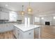 Open concept kitchen featuring a large island, modern lighting, and views into the living area with a fireplace at 1245 Porters Call Dr, Wendell, NC 27591