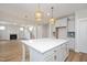 Stylish kitchen with a large island, modern lighting, and an open layout leading to the living area and staircase at 1245 Porters Call Dr, Wendell, NC 27591