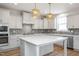 Spacious kitchen features a large island, modern appliances, stylish backsplash, and elegant pendant lighting at 1245 Porters Call Dr, Wendell, NC 27591