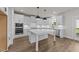 Modern kitchen with white cabinets, island, and stainless-steel appliances at 1245 Porters Call Dr, Wendell, NC 27591