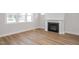 Cozy living space with a classic fireplace, wood-look flooring, and bright natural light from the windows at 1245 Porters Call Dr, Wendell, NC 27591
