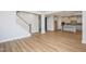 Open-concept living space with wood floors and view of the kitchen and stairs, creating an inviting atmosphere at 1245 Porters Call Dr, Wendell, NC 27591