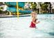 A cute little girl smiles as plays in the community splashpad with fountains and a slide at 1245 Porters Call Dr, Wendell, NC 27591