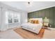 Serene bedroom with a plush bed, natural rug, and accent wall with elegant sconces at 1309 Pecora Ln, Raleigh, NC 27607