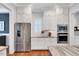 Modern kitchen features stainless steel refrigerator, white cabinets, and an eat-in kitchen bar at 1309 Pecora Ln, Raleigh, NC 27607