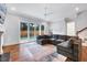Living room with hardwood floors, fireplace, large windows, and a dark gray L shaped couch at 1309 Pecora Ln, Raleigh, NC 27607