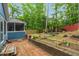 Spacious backyard with a patio area, screened-in porch, a fire pit, and green trees at 1487 Kentucky Ave, Sanford, NC 27332