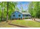 Charming single-story home with blue siding, a metal roof, a yellow front door, and attractive landscaping at 1487 Kentucky Ave, Sanford, NC 27332