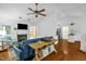 Open concept living space with fireplace, wood floors, ceiling fan and access to the dining area and kitchen at 1487 Kentucky Ave, Sanford, NC 27332