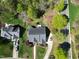 An aerial view shows a well-maintained home with mature trees, landscaped yard, and a driveway leading to the street at 1500 St Andrews Dr, Mebane, NC 27302