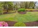 An eye-level view of the home's backyard with mature trees and luscious greenery at 1500 St Andrews Dr, Mebane, NC 27302