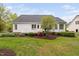 A well-manicured backyard with a white house and a wooden deck and beautiful landscaping at 1500 St Andrews Dr, Mebane, NC 27302