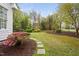 A lush green backyard featuring stepping stones, beautiful plants and a serene view of the surrounding trees at 1500 St Andrews Dr, Mebane, NC 27302