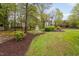 A lush backyard featuring an arbor, mature trees, and manicured landscaping offering a private outdoor space at 1500 St Andrews Dr, Mebane, NC 27302