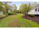 A sprawling backyard features a lush green lawn, mature trees, and well-manicured landscaping at 1500 St Andrews Dr, Mebane, NC 27302
