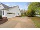 A long concrete driveway leading to a spacious two-car garage and a beautifully landscaped backyard at 1500 St Andrews Dr, Mebane, NC 27302