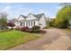 Charming white two-story home with a well-manicured lawn and beautiful landscaping at 1500 St Andrews Dr, Mebane, NC 27302